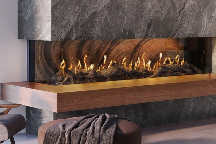 Three-sided linear fireplace with a wood mantel in a marble surround