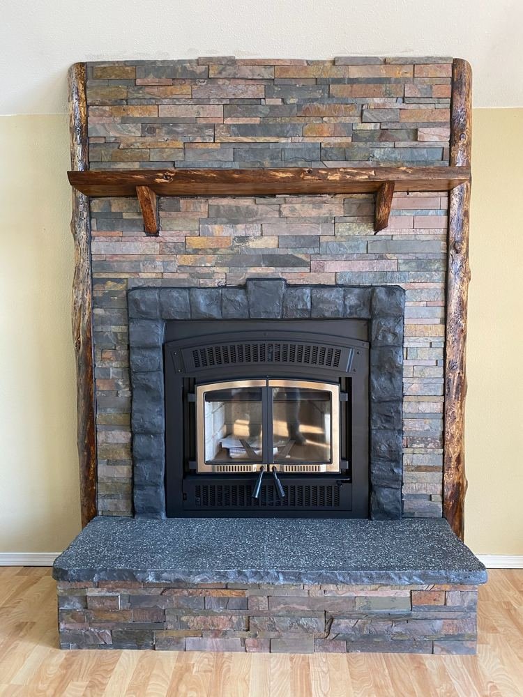 Finished stone fireplace with rustic log mantel